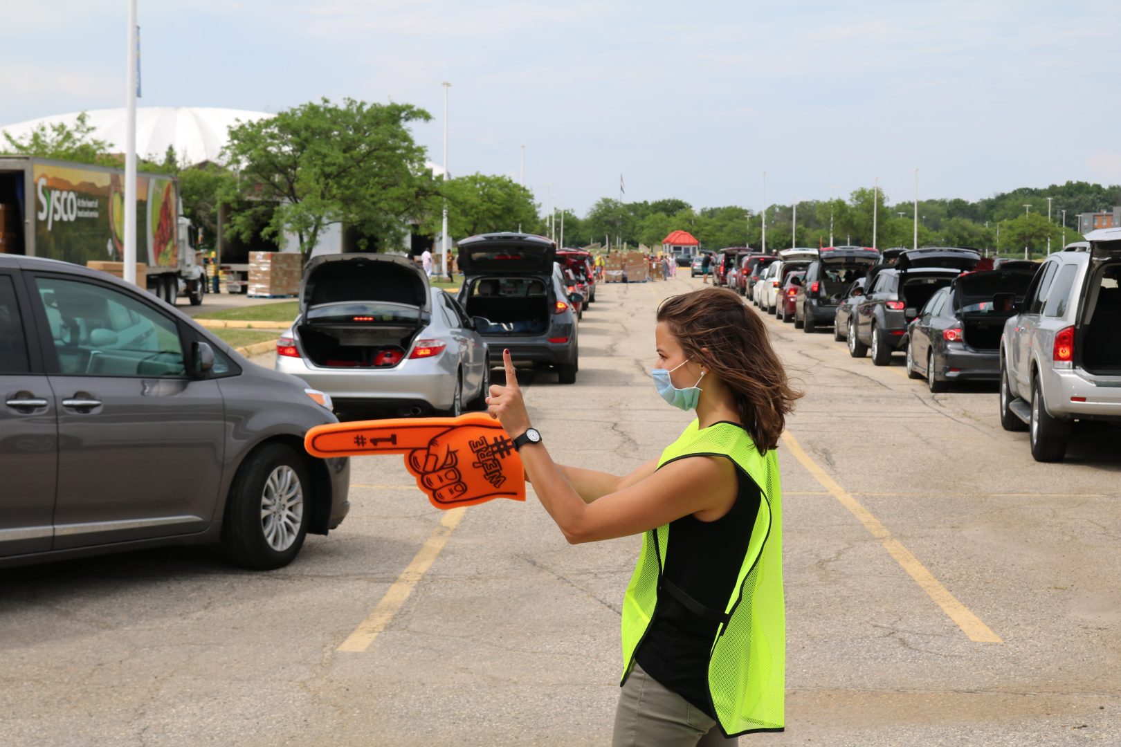 Second Harvest staff person directing traffic at a food distribution site.