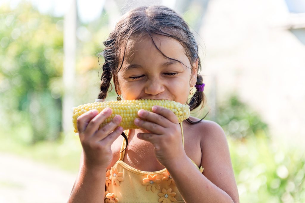 girl eating corn on the cob